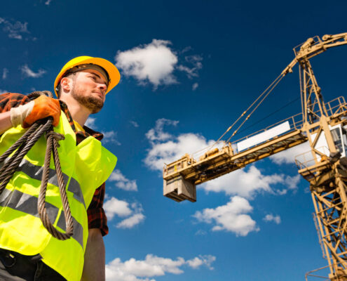 Ouvrier grutier sur chantier avec grue de construction